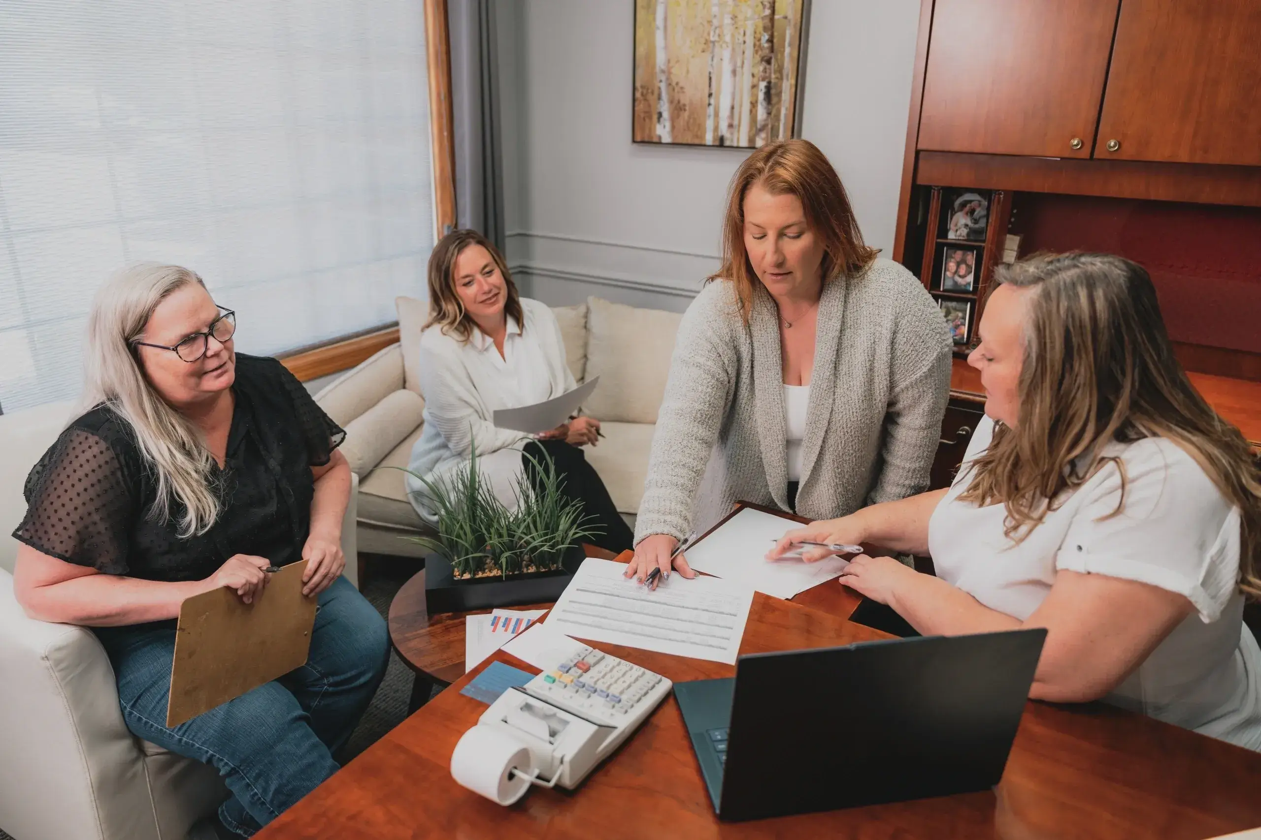Four women collaborating in an office meeting.